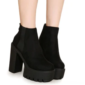 Black gothic platform ankle boots worn on female model's legs, side view displaying chunky square heel and elegant silhouette