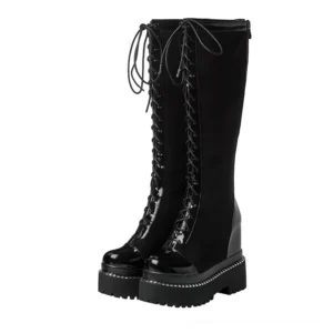 Black gothic platform knee-high boots with lace-up front and patent leather, front three-quarter view showing thick platform sole and round toe