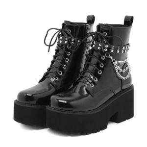 Black patent leather gothic platform combat boots with metal chain decoration, front view showing glossy finish and studded ankle details