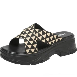 Black and khaki gothic platform crisscross sandals with geometric triangle straps, side front view showing chunky black sole