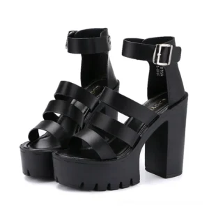 Black gothic platform sandals with thick chunky heels and multi-strap open toe design, front three-quarter view featuring adjustable buckle ankle strap