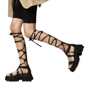 Black gothic knee-high lace-up platform sandals, side profile view worn by model