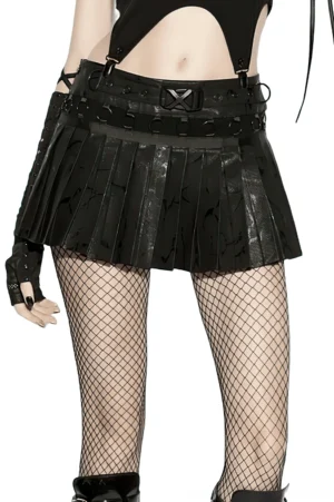 Black pleated faux leather mini skirt with metal ring hardware, front left view on model