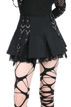 Black pleated gothic mini skirt with lace trim, lace stockings, and metal O-ring side straps, front low angle view