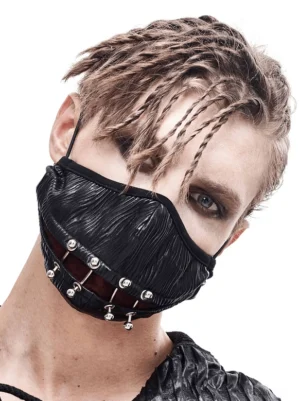 Black gothic punk face mask with metal piercing rings worn by male model with braided hair, front three-quarter view showcasing wrinkled faux leather and industrial cyberpunk aesthetic