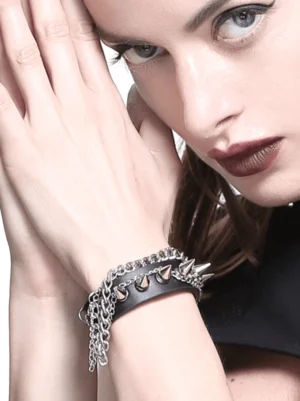 Black gothic punk studded chain bracelet worn on female model wrist, close-up front view showing silver metal spikes and chain details