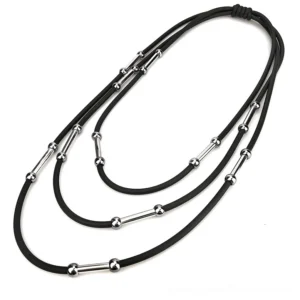 Handmade black rubber rope necklace overhead flat lay showing elastic knot closure and metal decorations