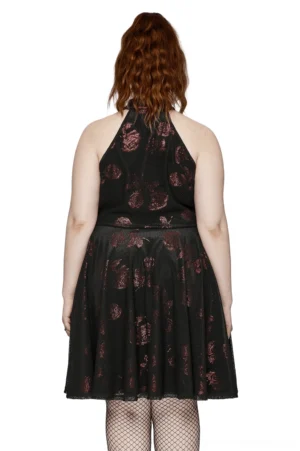 Black velvet gothic rose A-line dress back view on model, showing open halter style and A-line silhouette with fishnet stockings