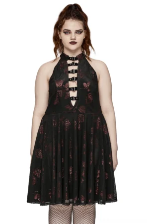 Plus-size model wearing black velvet gothic rose A-line dress with deep V-neck and metal buckles, styled with fishnet stockings - full front view