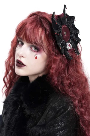Black gothic hair clip with rose cross and spiderweb pattern displayed on model's right side, featuring intricate lace trim and skull charm