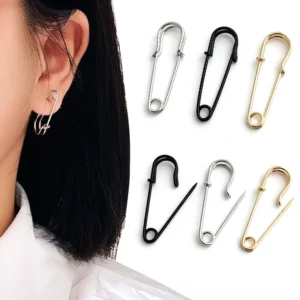 Gothic safety pin cross ear studs worn on model - punk rock alternative earrings in black, silver, and gold color options