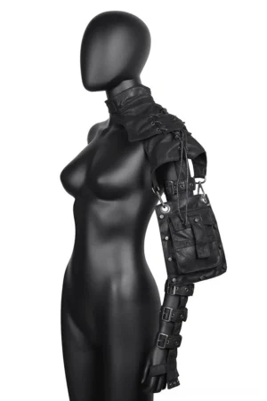 Black gothic shoulder harness bag with metal studs and adjustable arm straps, displayed on female mannequin in left side view showing lace-up design and hanging utility pouch