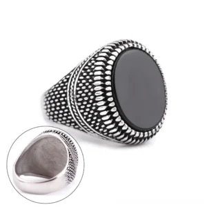 Vintage silver plated gothic signet ring showing side profile with round black stone inlay and detailed embossed band pattern