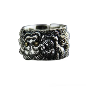 Close-up frontal detail of gothic silver ring featuring engraved foo dog guardian beast with vintage patina finish and contrasting gold accent elements