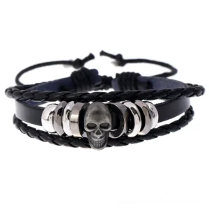 Black leather handwoven skull bracelet with silver charm, flat lay top view showing multi-layer braided construction and central skull ornament
