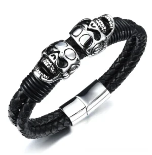 Black braided leather skull bracelet with polished stainless steel skull charms, close-up detail view