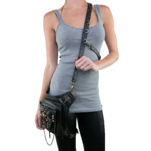 Woman wearing black steampunk crossbody bag with bronze hardware, front view showing flap closure and decorative skull details