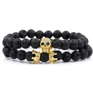 Gold tone skull and crown beaded gothic bracelet with black lava stone beads, studio flat lay