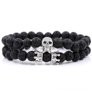 Silver tone skull and crown beaded gothic bracelet with black lava stone beads, top-down studio view