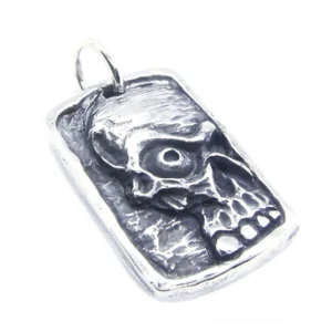 Unisex gothic ghost skull dog tag pendant with embossed single-eye design, front oblique view showing vintage silver stainless steel finish