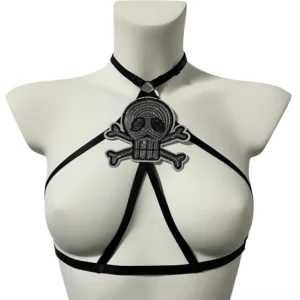 Gothic skull embroidered open chest harness bra front close-up view showcasing black satin straps and embroidered skull crossbone badge with halter neck design
