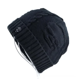 Black alternative skull winter beanie with ribbed rolled brim and metal skull hardware, side angle view