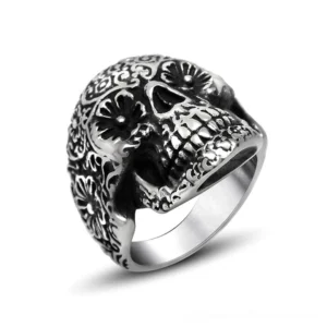 Ornate gothic skull ring with floral engravings in polished stainless steel, front view on white background