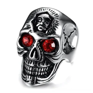 Gothic skull ring with red zirconia eyes, antique silver finish, front three-quarter view showing embossed facial details