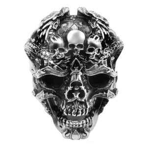 Sterling silver gothic skull ring with intricate multi-skull engravings and dragon details, front top-down view showcasing layered carving design