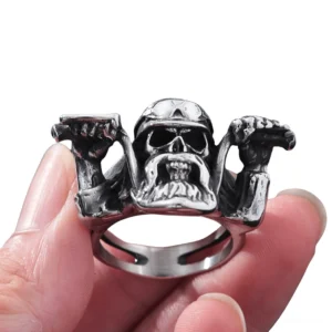 Stainless steel gothic skull ring on human finger showing hollow band design and detailed helmet features from front view