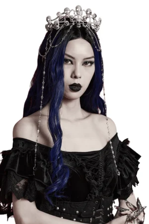Silver metal skull crown tiara with blue-streaked hair model three-quarter side portrait showing chain details and crystal pendants