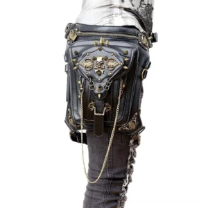 Black gothic waist bag with bronze skull rivets worn as leg holster on female model, rear view showing adjustable strap and hanging chains