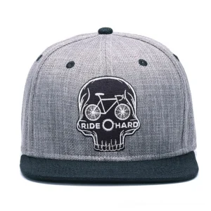Front view of gothic snapback baseball cap featuring embroidered skull and ride hard text on heather gray