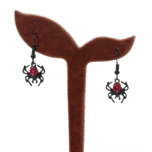 Gothic spider earrings displayed on felt stand, side profile showing hanging length and red crystal details