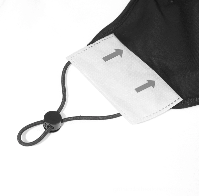 Flat lay lifestyle image of gothic black spiderweb face mask with adjustable buckle straps against minimal background