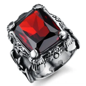 Close-up detail of gothic square blood red zircon ring highlighting intricate metal claw setting and embossed patterns on the stainless steel band