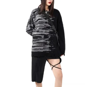 Black gothic distressed knit sweater full body side view on female model with crossbody bag and cutout pants for streetwear styling inspiration