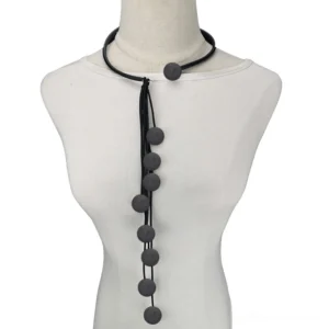 Black rubber gothic tassel lariat necklace with dark grey round matte pendants displayed on dress form mannequin front view