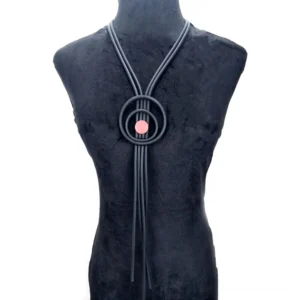 Dark gray gothic tassel necklace with pink accent ornament on black velvet mannequin, studio lighting showing elegant drape and professional styling