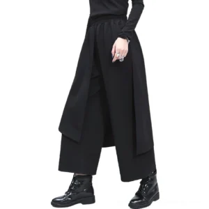 Black gothic women's trousers with double-layer front overlay, front-side angle showcasing asymmetric design and wide-leg silhouette