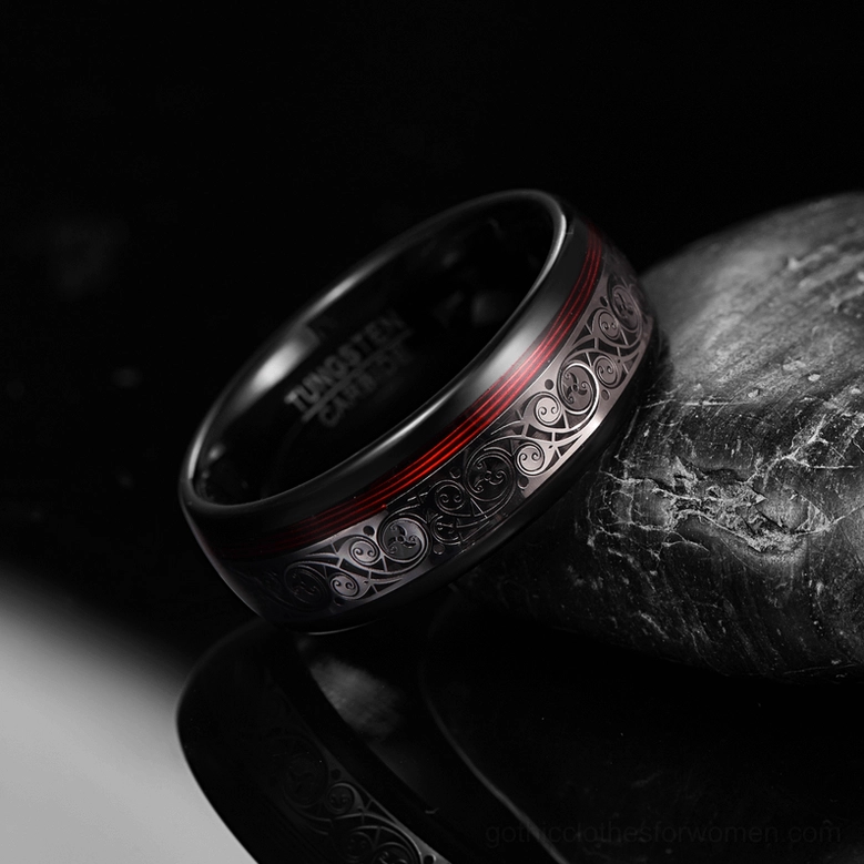 Polished black tungsten gothic ring with engraved ethnic patterns and red stripe accent, low angle view showcasing metal finish