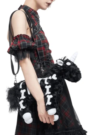 Black plush unicorn skeleton crossbody bag worn on model in punk goth outfit, rear carrying view showing white bone print detail