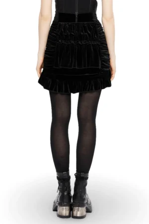 Black gothic velvet ruffle skirt back view showing rear zipper closure and ruched texture worn with sheer tights and platform boots