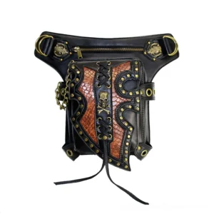 Flat lay close-up of steampunk gothic waist pouch showing brass hardware, zippered compartment, skull decoration, lace-up front, and chain accents