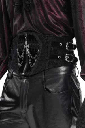 Side view of black gothic waist cincher displaying adjustable buckles and vintage paisley embossed texture with cross pendant