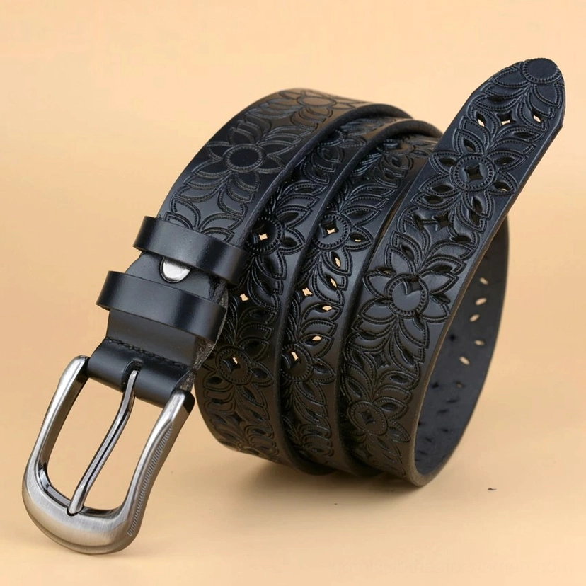 White hollow-carved leather gothic belt close-up showing the detailed geometric floral pattern and gunmetal pin buckle construction