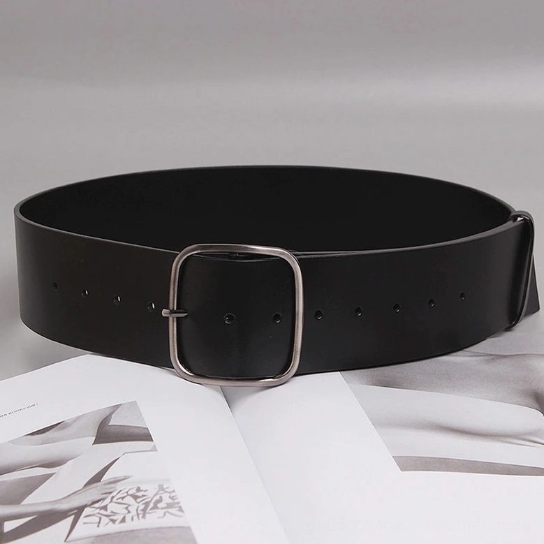 Black leather wide belt with silver square buckle and multiple adjustment holes displayed on side flat lay