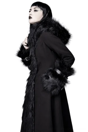 Side three-quarter view of gothic long coat showing faux fur hood, front fur panel detail, and buckled leather cuffs on alternative fashion model