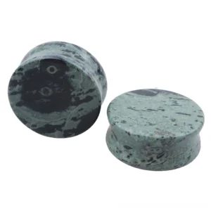 Green eye stone ear plugs and flesh tunnels arranged in graduated sizes, displaying natural dark green and black marbled stone texture with distinctive eye-like spots, professional flat lay product photography