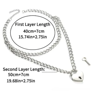 Heart lock chain necklace set with matching unlock key, flat lay overhead view showing dual chain lengths and silver-tone finish